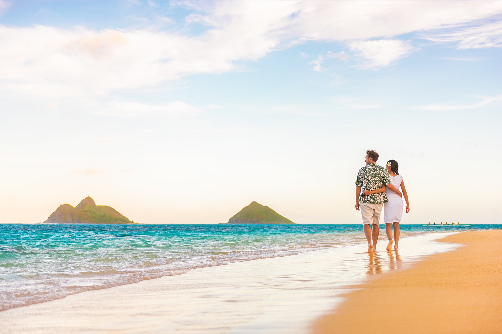 Hawaii beach vacation couple walking at sunset Hawaii beach vacation couple walking at sunset